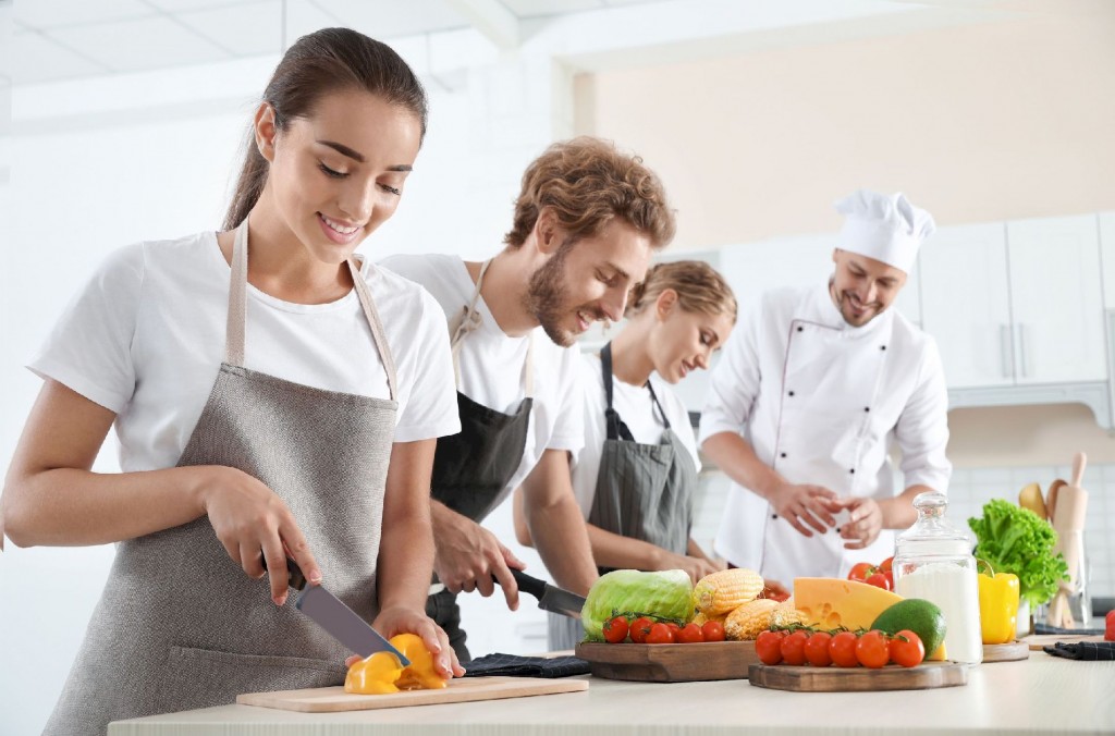 Group of people and male chef at cooking classes Group of people and male chef at cooking classes